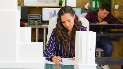 Female CAD architec looking at some blueprints on her table